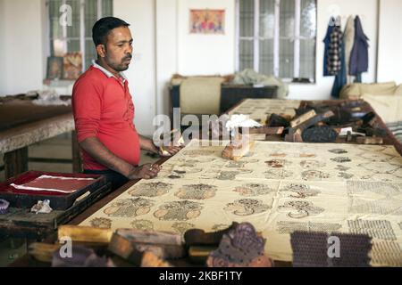 Une imprimante pour blocs de bois d'homme imprime avec des blocs de bois de Jain&Kriz sur du coton dans l'atelier d'impression de Bagru, district de Jaipur, Rajasthan, Inde, le 15 mars 2019. Chaque motif est le résultat d'un enregistrement précis de plusieurs blocs de bois l'un sur l'autre. L'impression sur tissus est une spécialité indienne, l'impression en blocs de bois est déjà utilisée depuis des centaines d'années. Bagru est célèbre pour l'impression exclusivement avec des couleurs naturelles. Les principaux experts sont membres de la communauté chippaa. (CHHI - colorant, pa - laisser quelque chose sécher au soleil). Les habitants de la région estiment qu'il y a environ 200 ateliers d'impression dans et autour de Bag Banque D'Images