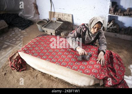 Une imprimeur de blocs de bois femelle imprime avec des blocs de bois avec de la boue sur du tissu de coton dans l'atelier d'impression à Bagru, district de Jaipur, Rajasthan, Inde, le 16 mars 2019. L'impression de boue est la tradition locale de Bagru. Le Dabu est un mélange résistant à la boue fait d'argile noire locale (kaali mitti), de poudre de blé (bidhan), de gomme de guar et d'eau de chaux. Une fois que l'imprimante applique le motif d'impression de dabu, une fine couche de sciure est arrosée sur le tissu pour l'empêcher de coller à lui-même pendant le processus de teinture. Les motifs fabriqués avec la résistance à la boue restent non colorés tandis que le reste du tissu est teint. Parfois ce pr Banque D'Images