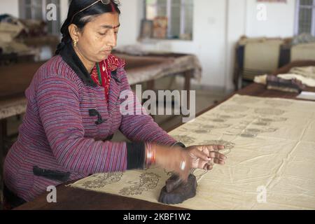 Une imprimante pour blocs de bois de femme imprime avec des blocs de bois de Jain&Kriz sur du coton dans l'atelier d'impression de Bagru, district de Jaipur, Rajasthan, Inde, le 15 mars 2019. L'impression sur tissus est une spécialité indienne, l'impression en blocs de bois est déjà utilisée depuis des centaines d'années. Bagru est célèbre pour l'impression exclusivement avec des couleurs naturelles. Les principaux experts sont membres de la communauté chippaa. (CHHI - colorant, pa - laisser quelque chose sécher au soleil). Les sections locales estiment qu'il y a environ 200 ateliers d'impression dans et autour de Bagru, qui colorent les tissus à l'aide de pâte de boue, de caoutchouc naturel et de flocons de blé. Co. De base organique Banque D'Images