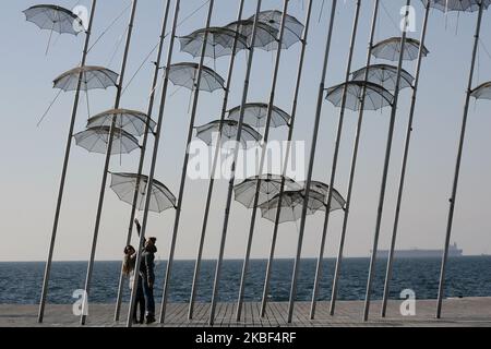 Les gens apprécient la sculpture des « parapluies » de feu artiste grec George Zongolopoulos sur la promenade de bord de mer de Thessalonique, Grèce sur 22 janvier 2020. (Photo de Grigoris Siamidis/NurPhoto) Banque D'Images
