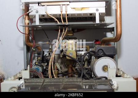 Sur le mur de la pièce, une chaudière à gaz est démontée pour réparation Banque D'Images