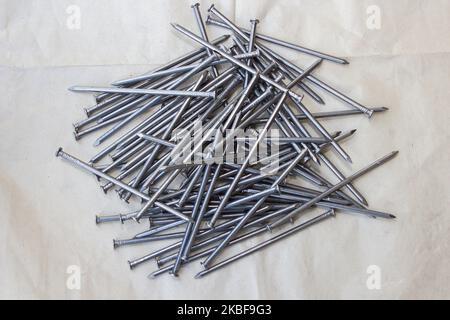 De nouveaux ongles reposent sur une pile de papier pour la toiture Banque D'Images