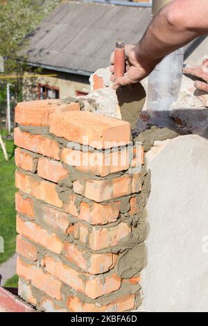 Maçon constructeur construire une cheminée sur le toit Banque D'Images