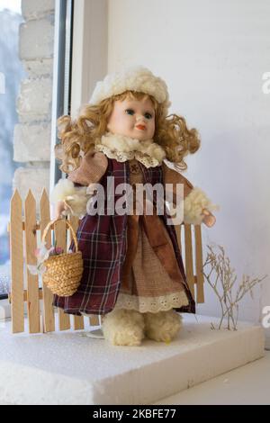 belle poupée dans un manteau d'hiver avec un panier Banque D'Images
