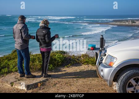 Les touristes apprécient le café lors d'un voyage en voiture, en regardant Struis point et Saxon Reef depuis les falaises près de Waenhuiskrans, Arniston, Afrique du Sud. Banque D'Images