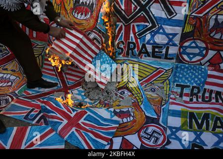 Un manifestant palestinien brûle une caricature du président américain Donald Trump et un drapeau israélien lors d'une protestation contre le plan de paix américain au Moyen-Orient, à Gaza, 27 janvier 2020. (Photo de Majdi Fathi/NurPhoto) Banque D'Images