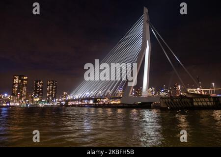 Erasmusbrug ou pont Erasmus vu illuminé dans la nuit dans le centre-ville de la ville néerlandaise, Rotterdam le 20 janvier 2020. Le long pont de 802m. Sur l'eau de la rivière New Meuse est un pont combiné à câbles et à bascules nommé d'après Desiderius Erasmus, conçu par Ben van Berkel. La construction et l'esturcture sont célèbres pour son architecture moderne et son design asymétrique de pylône bleu pâle ayant également le plus grand panneau de son type dans le monde. Le pont est un monument historique pour Rotterdam et les pays-Bas. (Photo de Nicolas Economou/NurPhoto) Banque D'Images