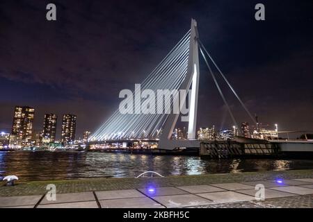 Erasmusbrug ou pont Erasmus vu illuminé dans la nuit dans le centre-ville de la ville néerlandaise, Rotterdam le 20 janvier 2020. Le long pont de 802m. Sur l'eau de la rivière New Meuse est un pont combiné à câbles et à bascules nommé d'après Desiderius Erasmus, conçu par Ben van Berkel. La construction et l'esturcture sont célèbres pour son architecture moderne et son design asymétrique de pylône bleu pâle ayant également le plus grand panneau de son type dans le monde. Le pont est un monument historique pour Rotterdam et les pays-Bas. (Photo de Nicolas Economou/NurPhoto) Banque D'Images