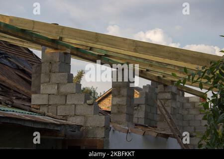 Une nouvelle construction de toit avec un cadre de treillis en bois faisant un sommet contre un ciel bleu avec des nuages. Banque D'Images