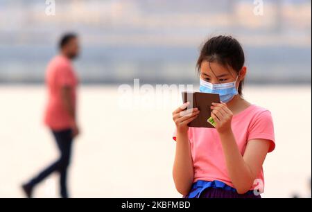 Une fille asiatique portant des masques protecteurs prend des photos du coucher de soleil à Galleface Green, Colombo, Sri Lanka. 28 janvier 2020. Le premier cas confirmé de coronavirus au Sri Lanka a été signalé après qu'une femme chinoise, âgée de 43 ans, qui est arrivée récemment au Sri Lanka depuis la province de Hubei, en Chine, a été testée positive pour le nouveau coronavirus, a déclaré le Sri Lankan Health promotion Bureau le 27. Le gouvernement sri-lankais a suspendu les visas à l'arrivée pour les touristes chinois et tous les visiteurs autres que les passagers ont été interdits d'entrer dans les locaux de l'aéroport international de Bandaranaike sur 28. (Photo de Thharaka Banque D'Images