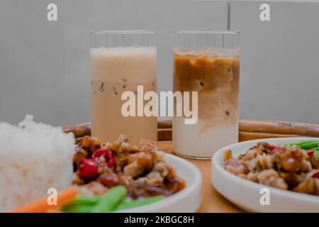 Deux verres de latte de café dans une table en bois et un premier plan flou Banque D'Images