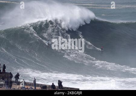 Les surfeurs de grandes vagues Andrew Cotton de Grande-Bretagne (R) et Lucas Chianca du Brésil lâcher une vague pendant le défi de surf de remorquage de WSL Nazaré à Praia do Norte à Nazaré, Portugal sur 11 février 2020. (Photo par Pedro Fiúza/NurPhoto) Banque D'Images