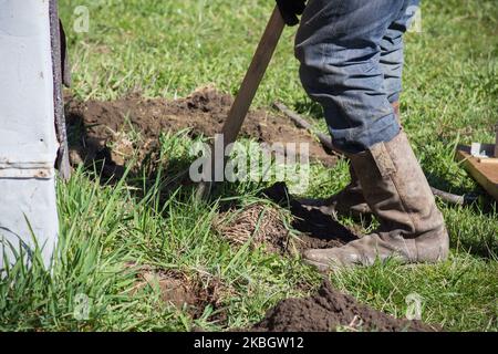 dans les vieilles bottes sales sur l'herbe à la pelle de fosse Banque D'Images