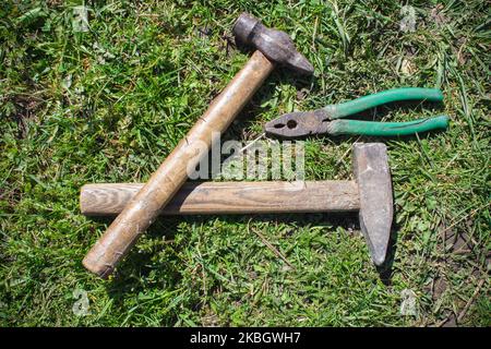 Outils sur fond rustique en bois et herbe Banque D'Images