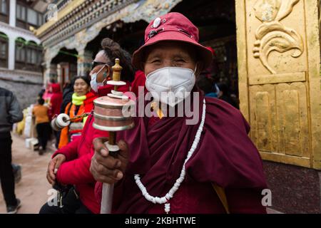 Une femme portant la robe d'un moine bouddhiste tibétain fait tourner une roue de prière à main levée à la stupa de Boudhanath le premier jour des célébrations du nouvel an tibétain (Losar) le 24 février 2020 à Katmandou, au Népal. Le Boudhanath stupa est un site classé au patrimoine de l'UNESCO et le monument bouddhiste tibétain le plus important en dehors du Tibet. (Photo de Wiktor Szymanowicz/NurPhoto) Banque D'Images