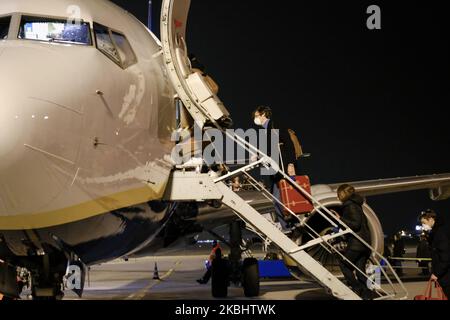 Les passagers portant un masque chirurgical montent à bord d'un avion à l'aéroport de Ronchi dei Legionari, près de Trieste, pendant l'épidémie de coronavirus dans le nord de l'Italie, sur 24 février 2020. (Photo de Jacopo Landi/NurPhoto) Banque D'Images