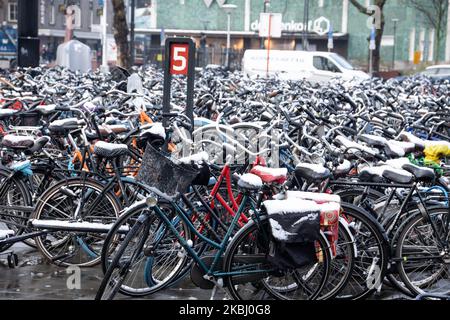 Les Hollandais à vélo, à vélo après la chute de neige dans le froid. Piles de milliers de bicyclettes garées à l'extérieur de la gare centrale d'Eindhoven Centraal. Images de la vie quotidienne du centre-ville après la chute de neige dans la ville d'Eindhoven sur 26 février 2020. La première neige pour l'hiver 2019-2020 avec de basses températures pour la région suivie d'une légère pluie. (Photo de Nicolas Economou/NurPhoto) Banque D'Images