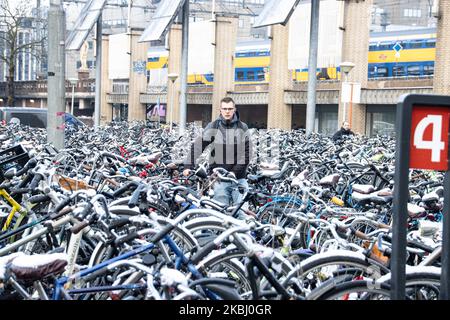 Les Hollandais à vélo, à vélo après la chute de neige dans le froid. Piles de milliers de bicyclettes garées à l'extérieur de la gare centrale d'Eindhoven Centraal. Images de la vie quotidienne du centre-ville après la chute de neige dans la ville d'Eindhoven sur 26 février 2020. La première neige pour l'hiver 2019-2020 avec de basses températures pour la région suivie d'une légère pluie. (Photo de Nicolas Economou/NurPhoto) Banque D'Images