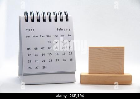 Calendrier de bureau blanc de février 2023 sur fond blanc avec espace en bois personnalisable pour le texte. Concept de calendrier. Banque D'Images