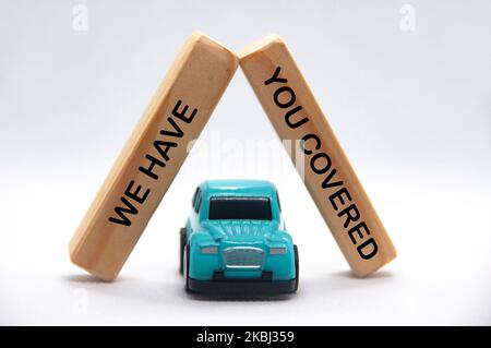 Nous vous avons couvert le texte sur des blocs de bois avec le modèle de voiture sur fond blanc. Concept d'assurance. Banque D'Images