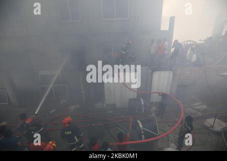 Des pompiers, des volontaires travaillent pour éteindre un incendie dans une usine de vêtements prêts à l'emploi (RMG) à Dhaka, au Bangladesh, sur 14 mars 2020. (Photo de Rehman Asad/NurPhoto) Banque D'Images