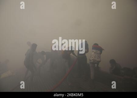 Des pompiers, des volontaires travaillent pour éteindre un incendie dans une usine de vêtements prêts à l'emploi (RMG) à Dhaka, au Bangladesh, sur 14 mars 2020. (Photo de Rehman Asad/NurPhoto) Banque D'Images