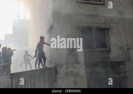 Des pompiers, des volontaires travaillent pour éteindre un incendie dans une usine de vêtements prêts à l'emploi (RMG) à Dhaka, au Bangladesh, sur 14 mars 2020. (Photo de Rehman Asad/NurPhoto) Banque D'Images