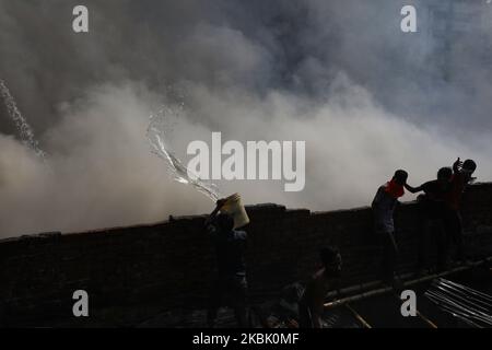 Des pompiers, des volontaires travaillent pour éteindre un incendie dans une usine de vêtements prêts à l'emploi (RMG) à Dhaka, au Bangladesh, sur 14 mars 2020. (Photo de Rehman Asad/NurPhoto) Banque D'Images