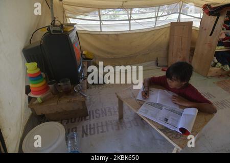 Un enfant survivant de la catastrophe du tremblement de terre et la faction ont étudié dans leurs tentes dans le camp de réfugiés de Balaroa, à Palu, dans le centre de Sulawesi, sur 18 mars 2020. Le gouvernement local a temporairement interrompu les activités scolaires dans la région afin d'anticiper la propagation du virus corona (COVID-19) en Indonésie. D'après les données gouvernementales, en 18 mars 2020, le nombre de décès dus au virus corona en Indonésie a atteint 19 000 personnes. (Photo par Mohamad Hamzah/NurPhoto) Banque D'Images