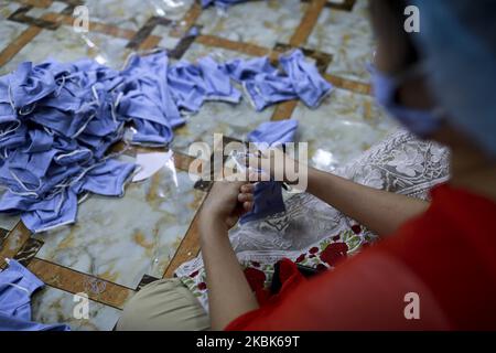 Les travailleurs d'une ONG font un masque pour les distribuer gratuitement parmi les gens comme mesure préventive contre le coronavirus, à Dhaka, au Bangladesh, sur 18 mars 2020. (Photo de Kazi Salahuddin Razu/NurPhoto) Banque D'Images