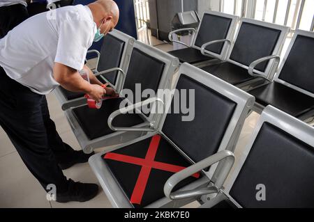 Les responsables des trains mettent des autocollants en croix sur les chaises d'attente à la gare de Pasar Senen, Jakarta, Le 19,2020 mars, l'activité consiste à fournir un panneau limitant aux utilisateurs de chemins de fer afin de pouvoir garder leur distance des autres passagers dans un effort de mettre en œuvre des appels de distanciation sociale pour empêcher la propagation du virus corona (covid-19) et de vérifier la température corporelle des passagers potentiels Dans le quartier de la gare de Pasar Senen. (Photo de Dasril Roszandi/NurPhoto) Banque D'Images