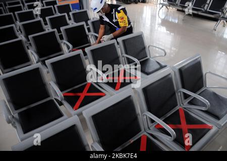 Les responsables des trains mettent des autocollants en croix sur les chaises d'attente à la gare de Pasar Senen, Jakarta, Le 19,2020 mars, l'activité consiste à fournir un panneau limitant aux utilisateurs de chemins de fer afin de pouvoir garder leur distance des autres passagers dans un effort de mettre en œuvre des appels de distanciation sociale pour empêcher la propagation du virus corona (covid-19) et de vérifier la température corporelle des passagers potentiels Dans le quartier de la gare de Pasar Senen. (Photo de Dasril Roszandi/NurPhoto) Banque D'Images