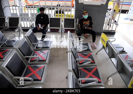 Les responsables des trains mettent des autocollants en croix sur les chaises d'attente à la gare de Pasar Senen, Jakarta, Le 19,2020 mars, l'activité consiste à fournir un panneau limitant aux utilisateurs de chemins de fer afin de pouvoir garder leur distance des autres passagers dans un effort de mettre en œuvre des appels de distanciation sociale pour empêcher la propagation du virus corona (covid-19) et de vérifier la température corporelle des passagers potentiels Dans le quartier de la gare de Pasar Senen. (Photo de Dasril Roszandi/NurPhoto) Banque D'Images