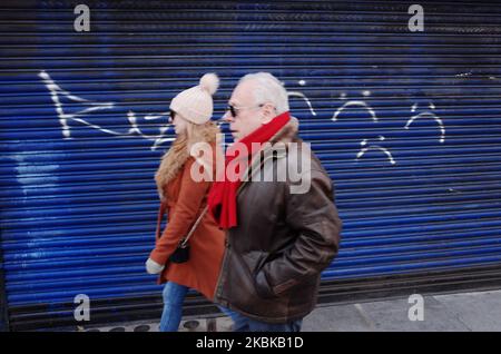 Les gens marchent devant un restaurant de sushi fermé sur une route de Tottenham court presque déserte à Londres, en Angleterre, sur 21 mars 2020. Une grande partie du centre de Londres était pratiquement vide aujourd’hui, un jour après que le Premier ministre britannique Boris Johnson ait ordonné la fermeture de tous les pubs, bars, cafés et restaurants du pays. Cette décision constitue un renforcement des mesures visant à faire respecter la « distanciation sociale » qui est pressée pour les citoyens de réduire la croissance des infections au coronavirus covid-19. Des boîtes de nuit, des théâtres, des cinémas, des salles de sport et des centres de loisirs ont également été commandés fermés. Il restait des boutiques dans le centre de la capitale Banque D'Images