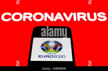 L'icône de l'application UEFA Euro 2020 est visible sur l'écran du smartphone avec le signe du coronavirus en arrière-plan dans cette illustration prise en Pologne sur 21 mars 2020. (Photo de Jakub Porzycki/NurPhoto) Banque D'Images