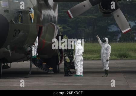 Les agents de santé effectuent un contrôle thermique à l'équipage de l'avion militaire C-130 de l'Armée de l'Air indonésienne qui transporte 9 tonnes de matériel médical en provenance de Chine, peu après l'atterrissage à la base aérienne de Halim Perdanakusuma, à Jakarta, sur 23 mars 2020. L'Indonésie a reçu 9 tonnes de matériel médical du gouvernement chinois pour accélérer la manipulation de la pandemi COVID-19 en Indonésie. (Photo par Aditya Irawan/NurPhoto) Banque D'Images