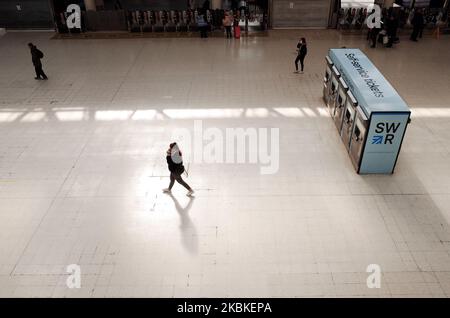 Les gens marchent à travers le concourse d'une station de Waterloo presque déserte à Londres, Angleterre, sur 23 mars 2020. Les services ferroviaires à travers le pays ont commencé à être réduits par rapport à aujourd'hui, en raison de chutes énormes de la demande de passagers. Toutefois, les services de base se poursuivent principalement pour permettre aux travailleurs de la santé, au personnel des services d'urgence et à d'autres travailleurs clés d'atteindre leurs lieux de travail. Les accords de franchise ferroviaire doivent également être temporairement suspendus, a annoncé aujourd'hui le ministère des Transports (DFT), le gouvernement nationalisant effectivement les chemins de fer pour protéger les compagnies de train de l'effondrement. Banque D'Images