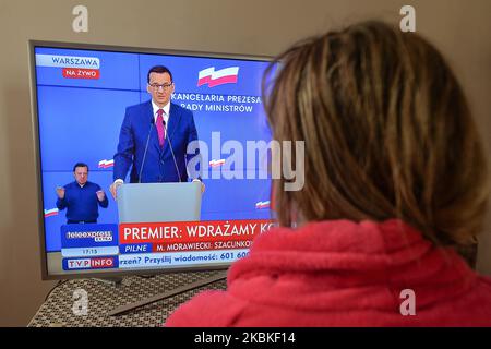 Une dame regarde sa télévision lors d'un discours télévisé du PM polonais Mateusz Morawiecki. Le Premier ministre Mateusz Morawiecki vient d'annoncer de nouvelles restrictions strictes dans le mouvement et les contacts entre les personnes. Avec plus de 775 cas de coronavirus en Pologne et 9 décès, le gouvernement polonais introduit de nouvelles restrictions pour la population. Mardi, 24 mars 2020, à Cracovie, en Pologne. (Photo par Artur Widak/NurPhoto) Banque D'Images