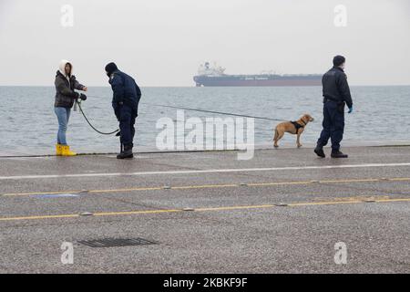 Un policier demande les documents de circulation d'une femme avec son chien à Thessalonique, en Grèce, le 24 mars 2020. Aujourd'hui est le deuxième jour du verrouillage total du pays de la Grèce. Toutes les personnes qui sont à l'extérieur de leur maison sont vérifiées par les policiers avec un masque et des gants pour les documents d'autorisation spéciaux ou SMS et ID qui leur permettent d'être à l'extérieur. Le gouvernement grec et le Premier ministre Kyriakos Mitsotakis ont mis en place l'écluse du pays avec la fermeture des magasins et des restrictions de circulation comme mesure préventive forte contre la propagation de Covid-19 Coronav Banque D'Images