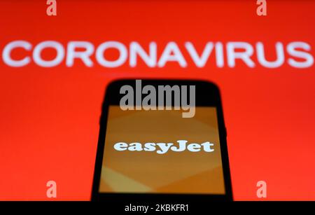 L'icône de l'application easyJet est visible sur l'écran du smartphone avec le signe du coronavirus en arrière-plan dans cette illustration prise en Pologne sur 24 mars 2020. (Photo d'illustration par Jakub Porzycki/NurPhoto) Banque D'Images
