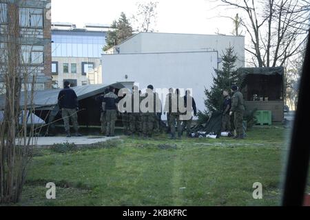 Le personnel de l'armée est vu près d'une tente camouflée sur le complexe de l'hôpital Szaserow à Varsovie, en Pologne, sur 24 mars 2020. Le PM polonais Mateusz Morawiecki a annoncé mardi de nouvelles restrictions à la libre circulation, semblables à celles mises en place plus tôt en Allemagne. Les restrictions font l'objet d'une interdiction de rassemblement de plus de deux personnes et de masses religieuses, une question litigieuse dans un pays largement dévot. Malgré l'attente du gouvernement que le nombre d'infections va augmenter de manière significative les élections présidentielles prévues pour May10 ne seront pas retardées. (Photo de Jaap Arriens/NurPhoto) Banque D'Images