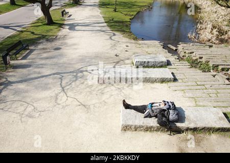 Un sans-abri est vu dormir au Vondelpark sur 27 mars 2020 à Amsterdam, pays-Bas. Le ministre néerlandais de la Justice et de la sécurité Ferdinand Grapperhaushas a ordonné de nouvelles mesures plus strictes pour lutter contre la propagation du coronavirus, dans les parcs, les rues et les espaces publics, les gens doivent pratiquer la distanciation sociale et garder 1,5 mètres, ceci pour un groupe de trois personnes ou plus (qui ne sont pas famille) , une amende de 400 euros sera remise. (Photo de Paulo Amorim/NurPhoto) Banque D'Images