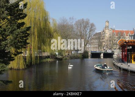 Un couple appréciant sur le bateau au canal sur 27 mars 2020 à Amsterdam, pays-Bas. Le ministre néerlandais de la Justice et de la sécurité Ferdinand Grapperhaushas a ordonné de nouvelles mesures plus strictes pour lutter contre la propagation du coronavirus, dans les parcs, les rues et les espaces publics, les gens doivent pratiquer la distanciation sociale et garder 1,5 mètres, ceci pour un groupe de trois personnes ou plus (qui ne sont pas famille) , une amende de 400 euros sera remise. (Photo de Paulo Amorim/NurPhoto) Banque D'Images