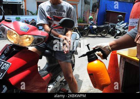 Les contrôles de serrage aux entrées résidentielles, les résidents s'enregistrer et s'en sont sortis en vaporisant des désinfectants et doivent se laver les mains à Pegangsaan Dua, Jakarta, en avril 1,2020. Les résidents qui ont l'auto-assistance pour resserrer l'examen à l'entrée de leur résidence vise à briser la chaîne de propagation de COVID-19, suite à l'augmentation de Covid-19 patients positifs dans la région de Jakarta. (Photo de Dasril Roszandi/NurPhoto) Banque D'Images