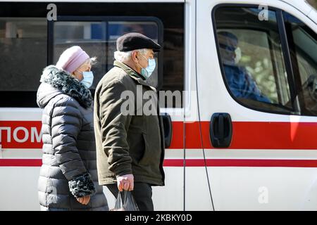 Personnes dans des masques de protection comme mesure préventive contre le coronavirus COVID-19 marchant près d'une voiture d'ambulance dans la rue à Kiev, Ukraine sur 03 avril 2020 (photo de Maxym Marusenko/NurPhoto) Banque D'Images