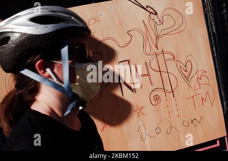 Une femme portant un rouleau masque skate devant un message d'amour pour le National Health Service (NHS), écrit sur les draps en bois d'un restaurant à bord d'un boardé sur New Oxford Street à Londres, en Angleterre, sur 4 avril 2020. Au Royaume-Uni, 41 903 cas de coronavirus covid-19 ont été confirmés, dont 4 313 sont morts. Le pays entre-temps est maintenant près de quinze jours dans son « verrouillage », qui doit être revu après une période initiale de trois semaines, bien qu'une prolongation soit largement attendue. Matt Hancock, secrétaire d'État britannique à la Santé et aux soins sociaux, a insisté sur le fait que c'était le cas Banque D'Images