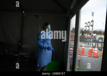 Alyssa Volkmer, 25 ans, met son équipement de protection personnel au centre de test COVID-19 et au centre d'évaluation de terrain de Stony Brook, New York. L'installation devrait tester 979 victimes présumées du coronavirus aujourd'hui, sur 4 avril 2020. (Photo par B.A. Van Sise/NurPhoto) Banque D'Images