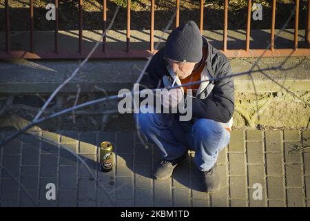 Un homme est vu allumer une cigarette tout en se reposant sur un trottoir public à Varsovie, en Pologne, sur 5 avril 2020. Malgré des températures croissantes, le gouvernement a exhorté les gens à rester et à respecter les règles de distanciation pour empêcher la propagation du coronavirus. La Pologne a vu sa plus forte augmentation de cas actifs avec 475 personnes nouvellement infectées testées dimanche. (Photo de Jaap Arriens/NurPhoto) Banque D'Images