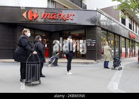 Les personnes portant un masque attendant sur la ligne a front un marché Carrefour à Paris sur 7 avril 2020, lors de l'enfermement en France pour tenter de stopper la propagation du nouveau coronavirus COVID-19. (Photo de Mehdi Taamallah/NurPhoto) Banque D'Images