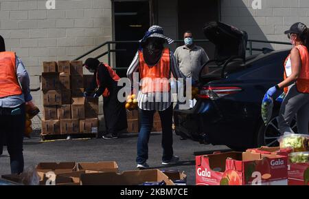 Des bénévoles de la Société islamique du centre de la Floride distribuent de la nourriture de la deuxième Harvest Food Bank du centre de la Floride aux familles dans le besoin lors d'un événement au drive-in sur 9 avril 2020 à Orlando, en Floride. La banque alimentaire a connu une demande record d'aide dans la région d'Orlando en raison des pertes d'emplois causées par la pandémie du coronavirus. (Photo de Paul Hennessy/NurPhoto) Banque D'Images